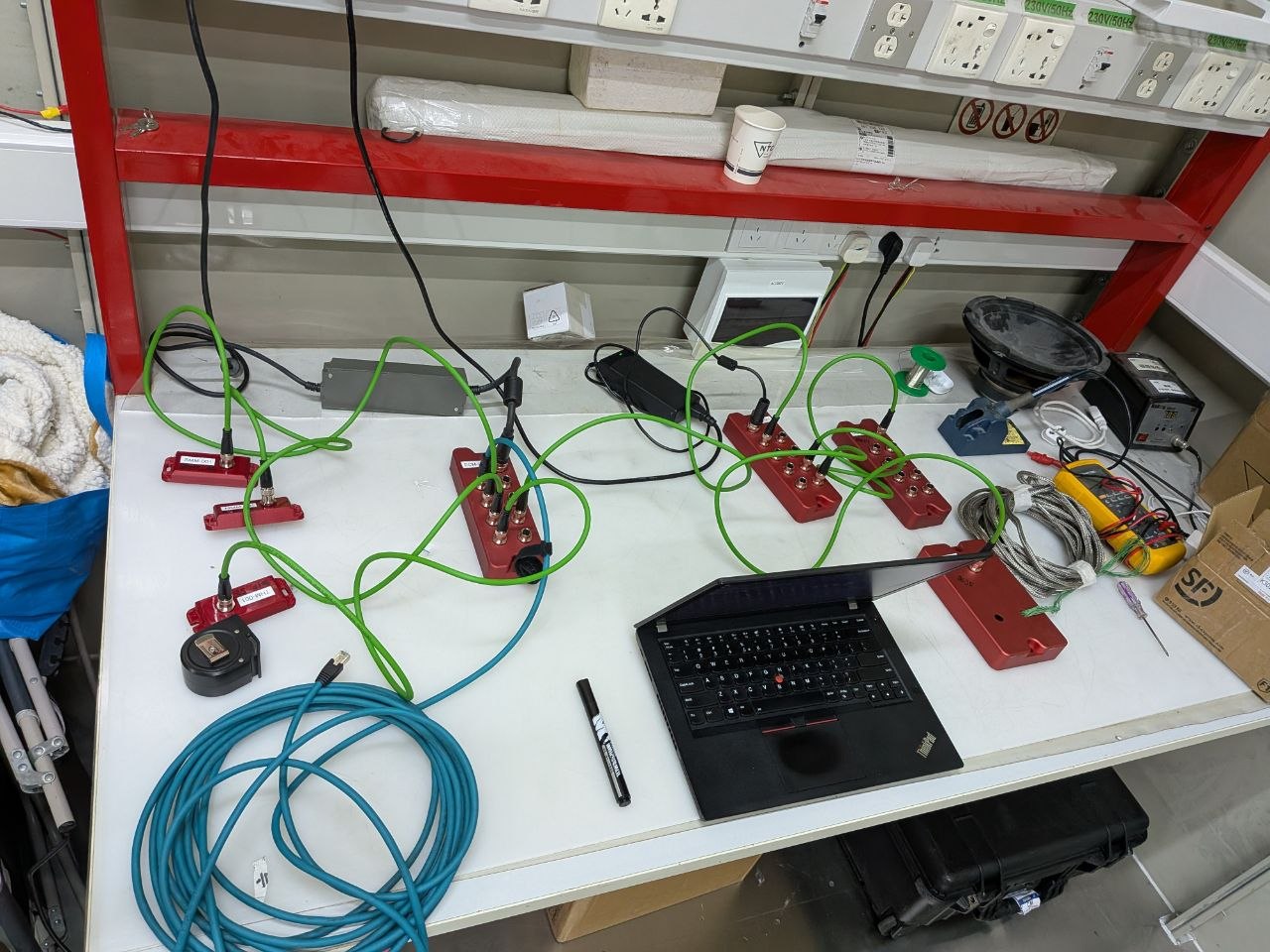 Full test bench at NTC — compute module, sensor nodes, M12 PoE cables, ThinkPad for monitoring