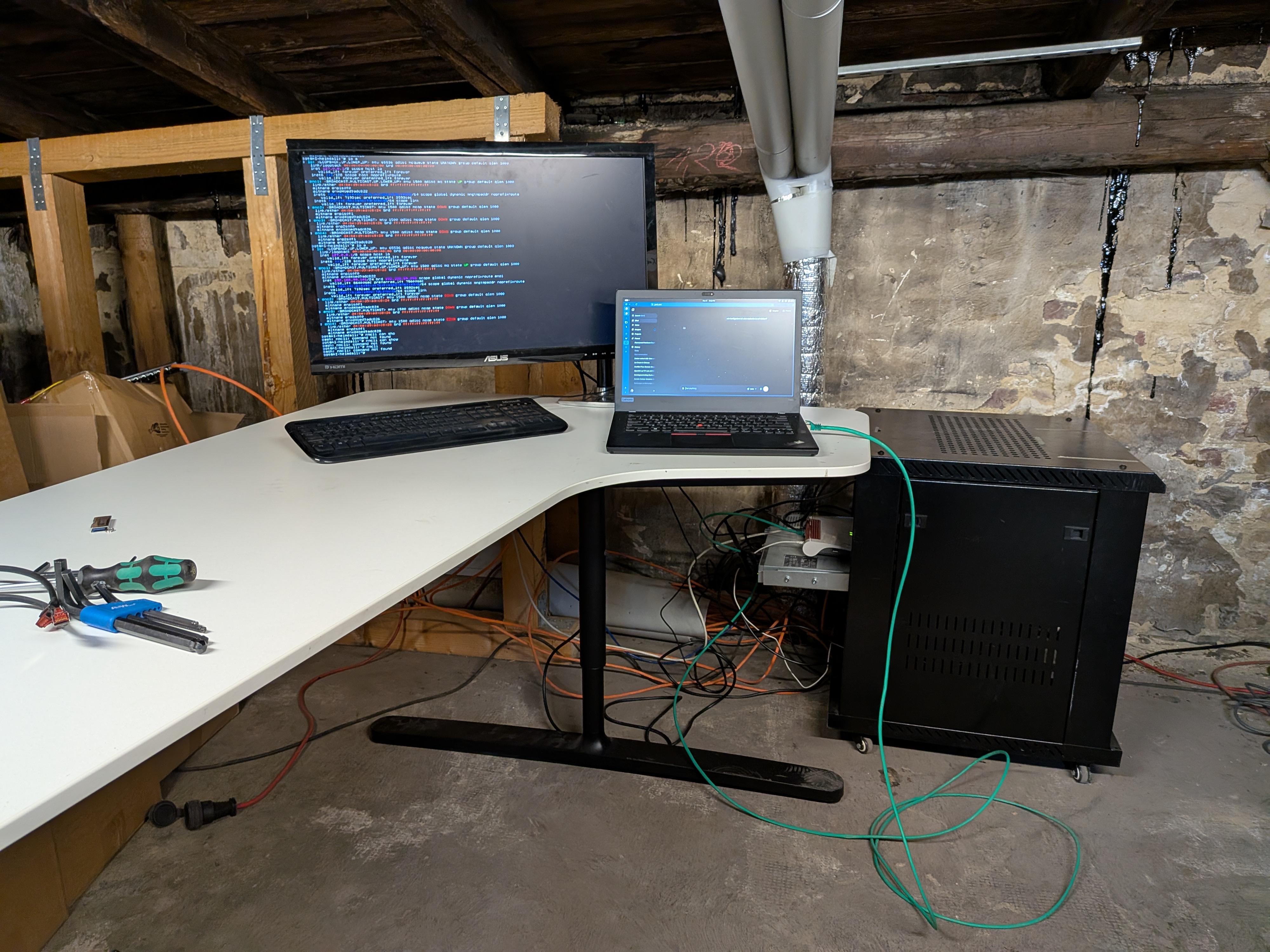 Setup workspace in the basement — AI-heimdall in the mini-rack on the right, terminal output on the monitor