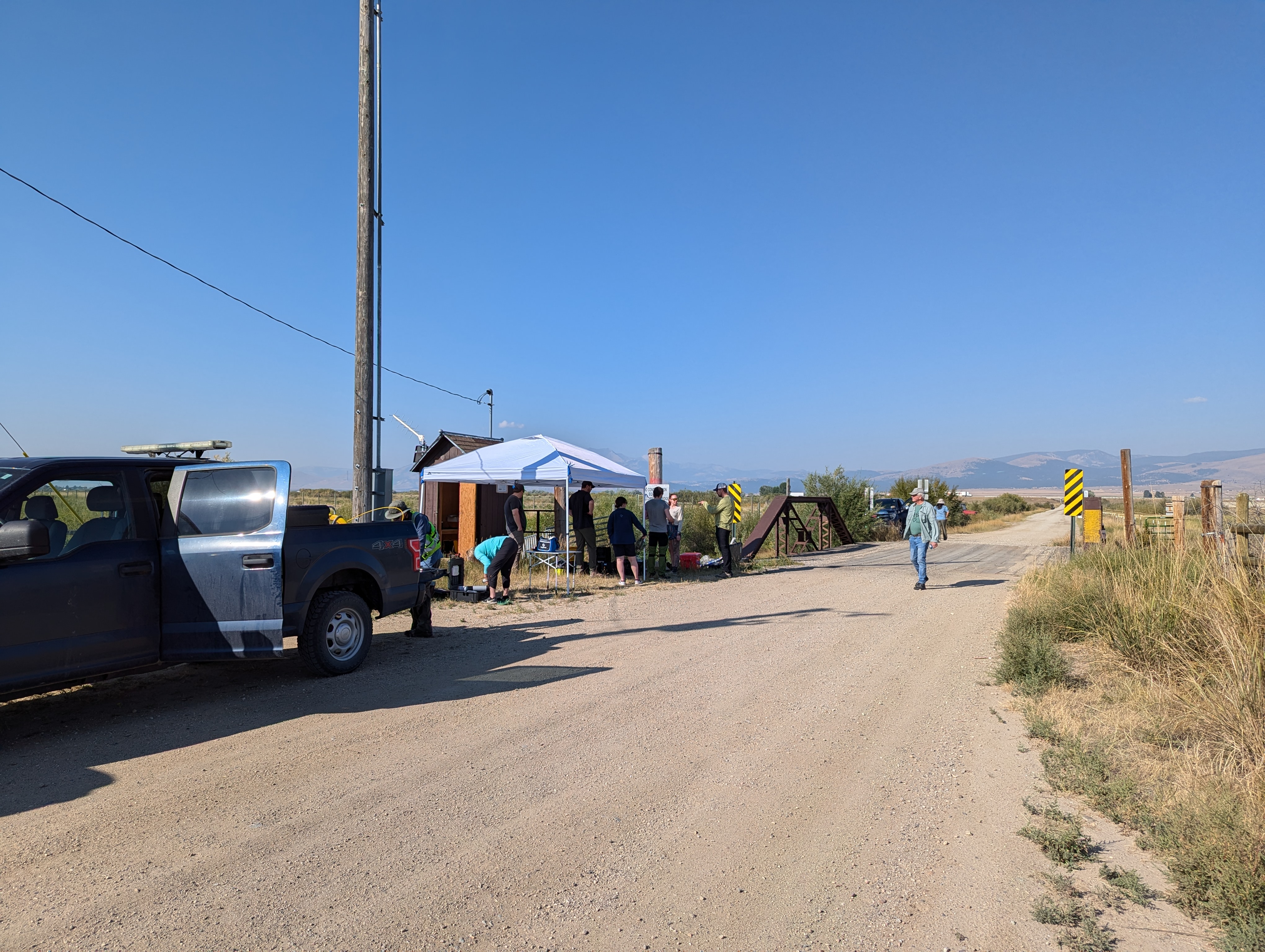 Deployment team at the Clark Fork site — bridge crossing, canopy tent, and a lot of cable