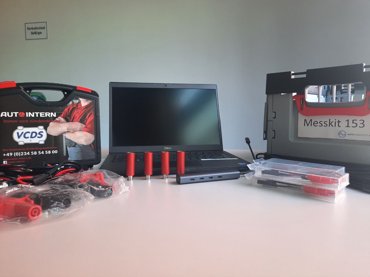 Demo setup at an automotive trade show — four scopes, a laptop, the Messkit 153 case