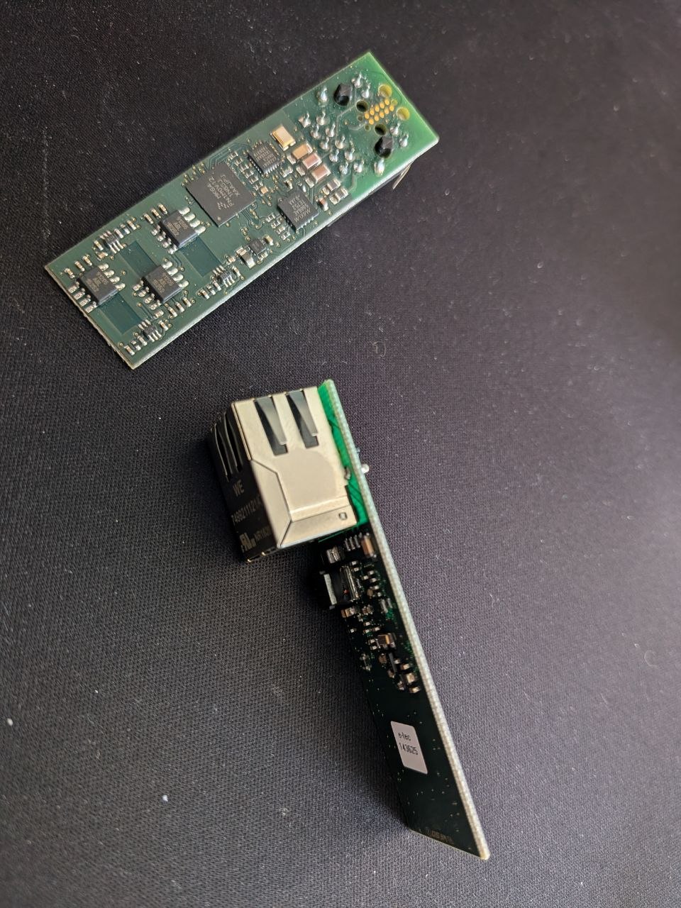Two bare PCBs: the sensor antenna board (top) and the PoE main board with RJ45 connector (bottom) — before any housing existed